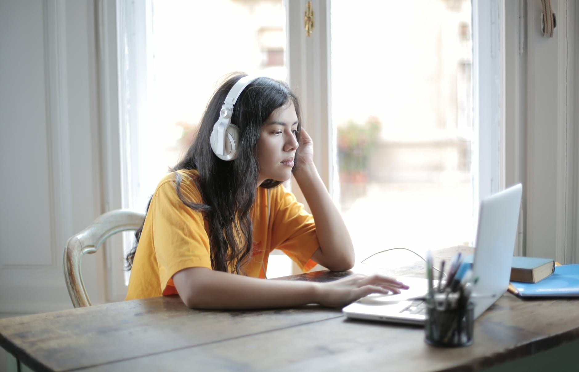 woman in yellow shirt wearing white headphones