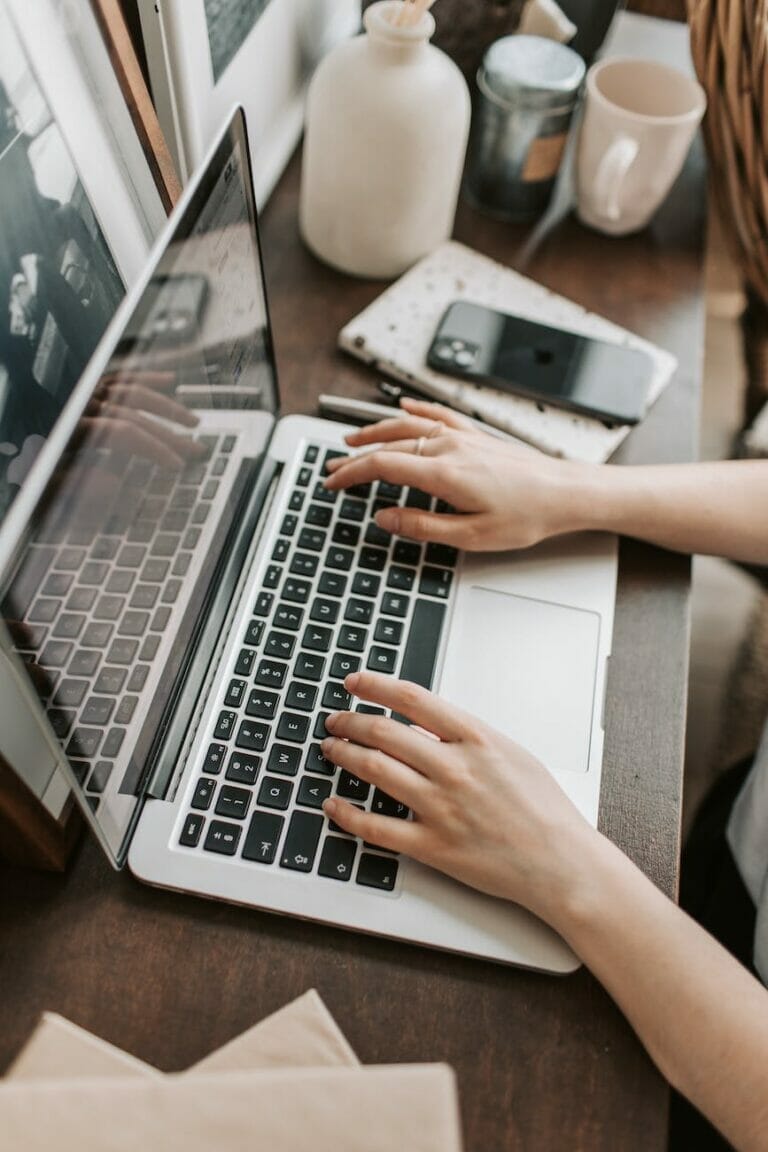 crop female freelancer using laptop at table at home