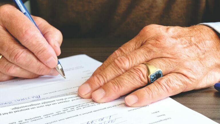 person signing document paper