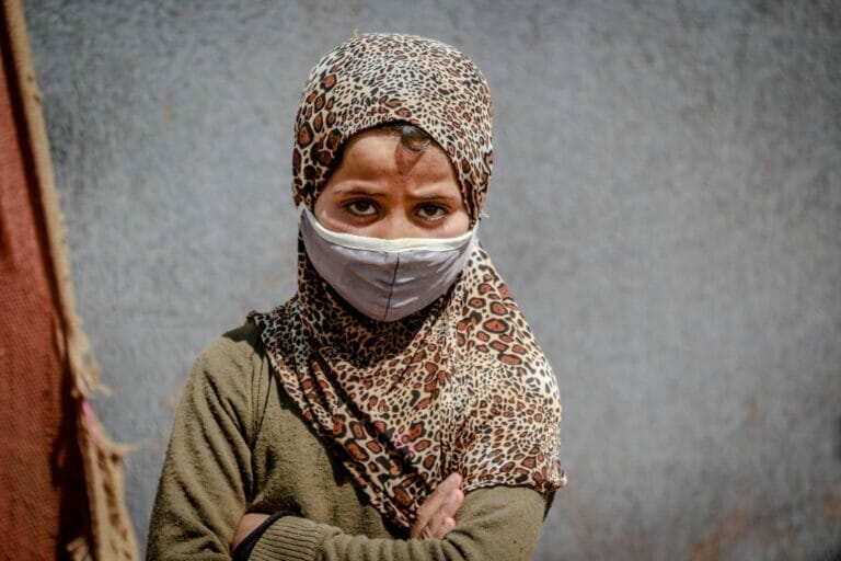 a young girl with a worried look wearing a face mask