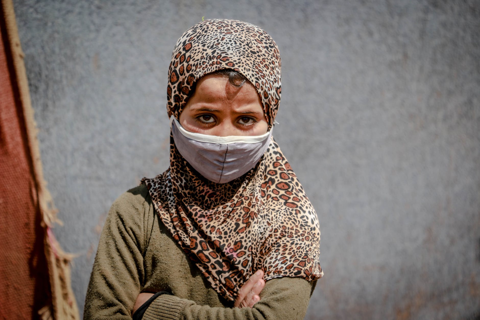 a young girl with a worried look wearing a face mask