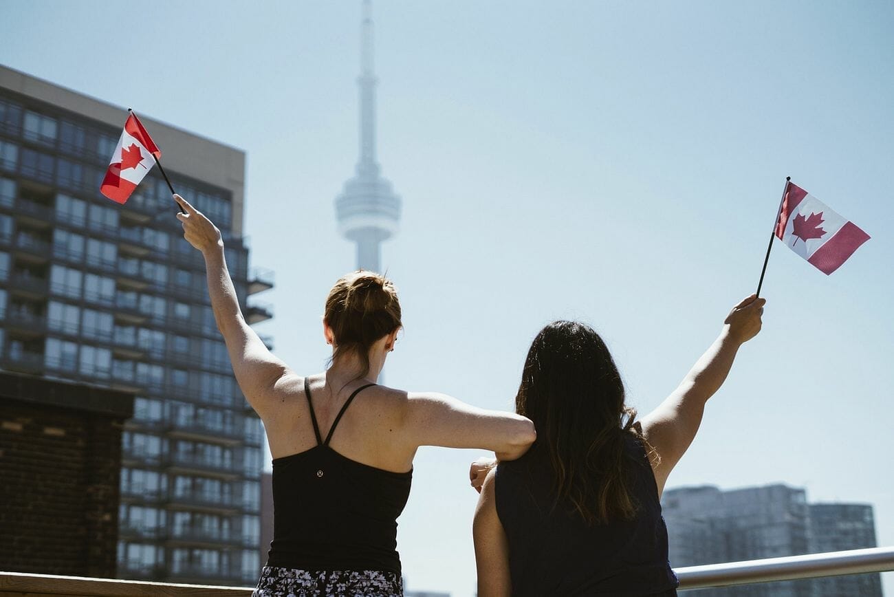 Women hold up Canadian flags